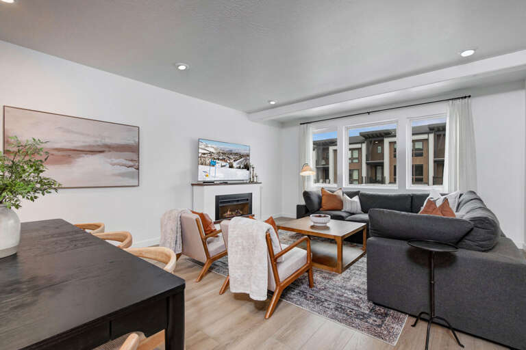 Unwind in your stylish living room with a cozy fireplace, plush sectional, and warm natural light streaming through oversized windows.