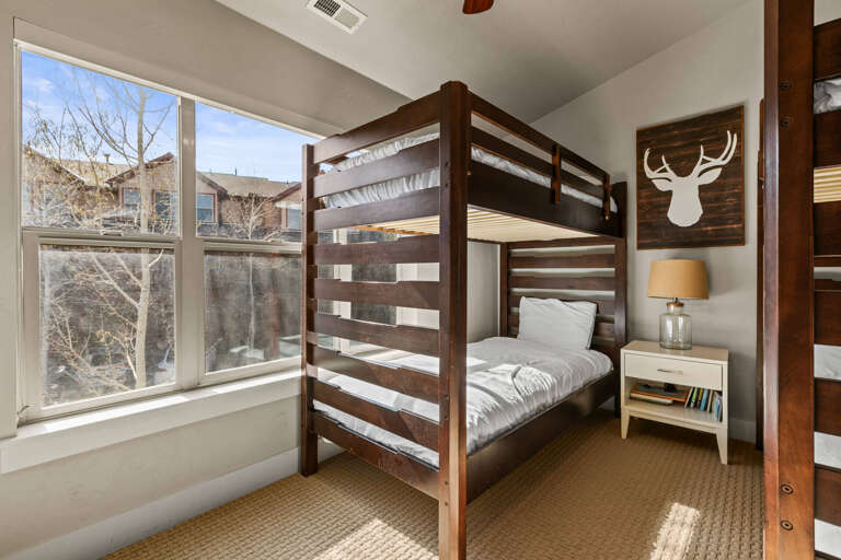 Cozy bunk room filled with natural light offers your group comfortable sleeping quarters with mountain lodge character and modern touches.