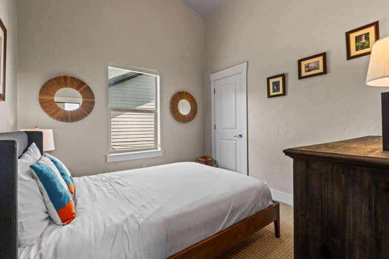 Sink into crisp linens in your serene bedroom, where rustic wooden accents and coastal-inspired décor create a peaceful retreat after a day of adventure.