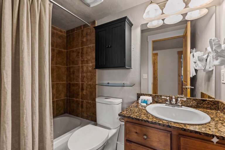 Your bathroom features a tiled shower, polished granite counters, and a modern vanity—a thoughtfully designed space where you'll refresh after mountain adventures.