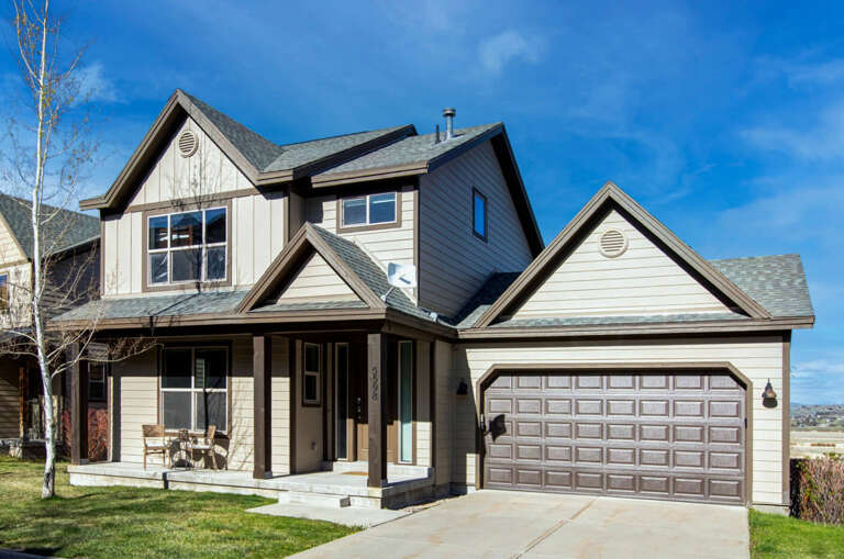 A beautiful two-story home featuring modern design with neutral siding and attached two-car garage in a residential neighborhood.