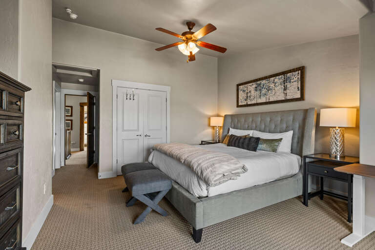 Sink into your plush tufted bed while the gentle ceiling fan keeps you cool. This peaceful bedroom offers comfort and style for your restful stay.