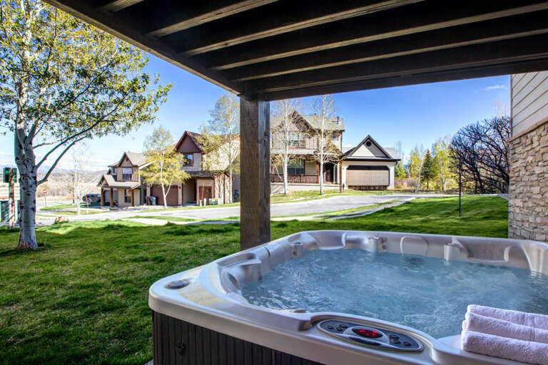 Soak in your private hot tub under rustic beams while overlooking peaceful neighborhood viewsâperfect for unwinding after exploring.