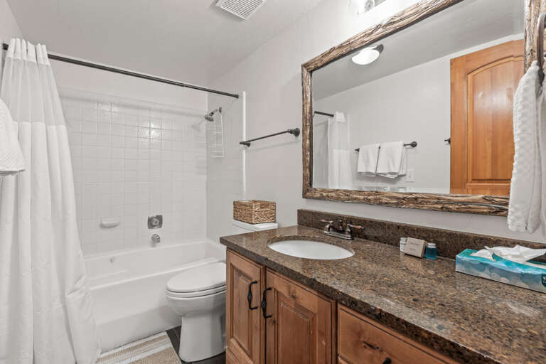 Refresh in your private bathroom with granite countertops and rustic wood accents.