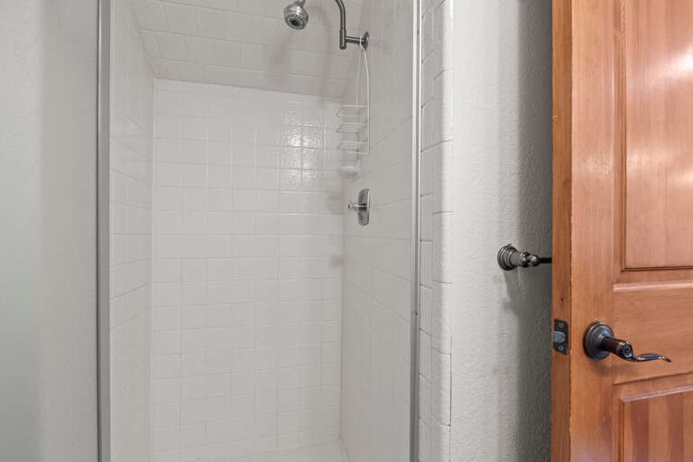 Step into your private shower with clean white tiles and modern fixtures, perfect for refreshing after a day of exploring.