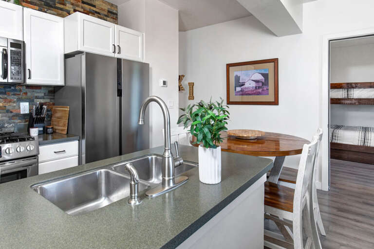 Cook with ease in your fully equipped kitchen featuring modern appliances and charming stone accents that create a warm, welcoming atmosphere.