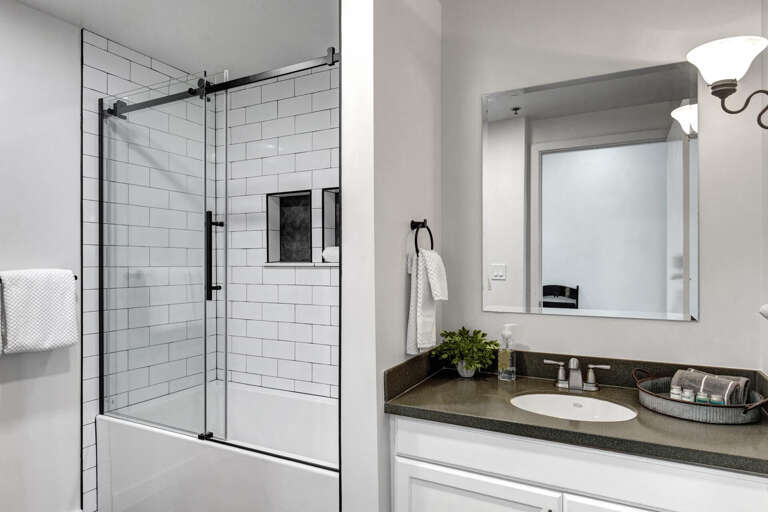 Fresh white subway tiles and sleek black fixtures create your perfect spa-like retreat for unwinding after exploring.