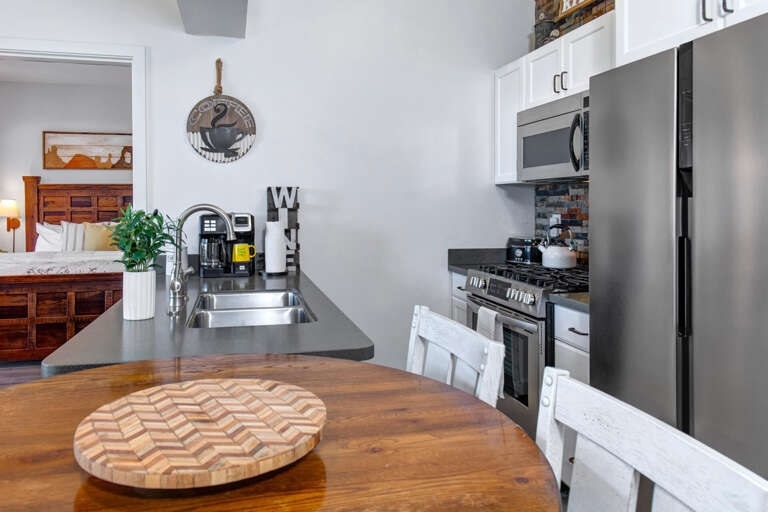 Your fully-equipped kitchen features stainless steel appliances and warm wood dining table for memorable meals together.