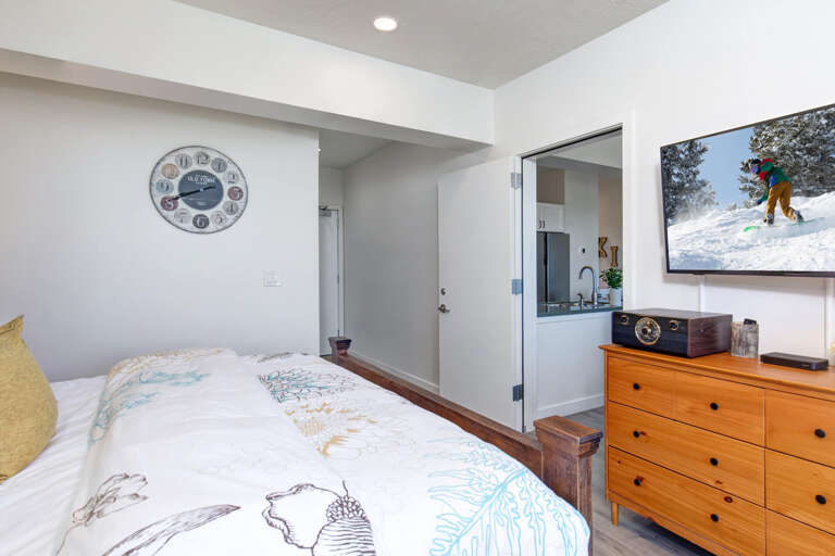 Unwind in your cozy bedroom with colorful bedding, vintage radio, and ski artwork creating the perfect mountain retreat atmosphere.