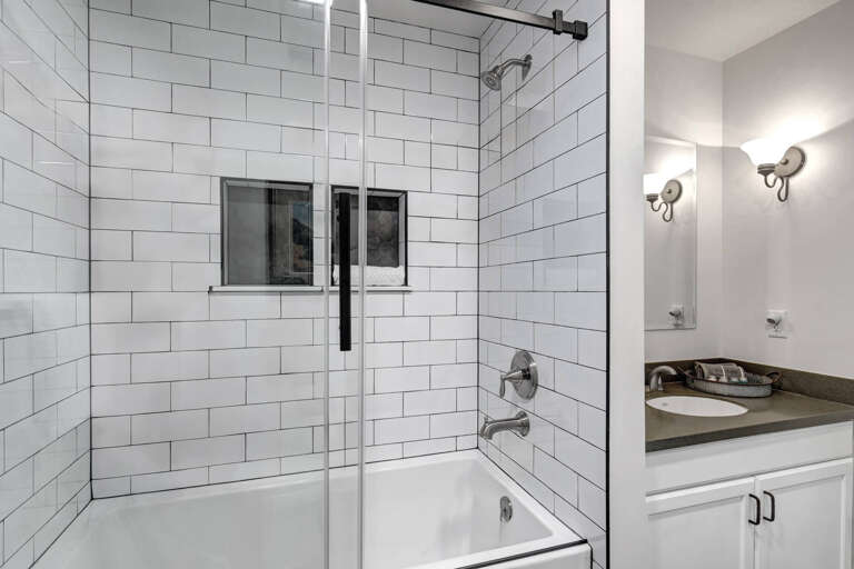 Unwind in your private bathroom with classic subway tile shower-tub combo and modern glass door.