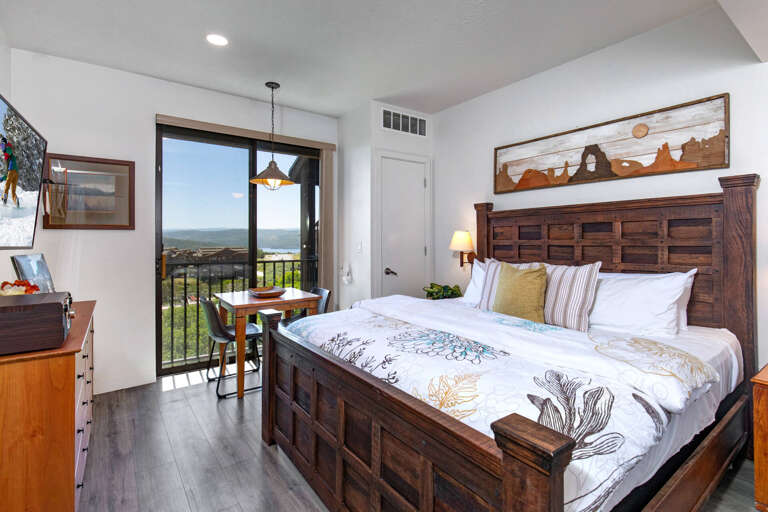 Wake up to stunning views from your private balcony! This cozy bedroom features rustic wood furnishings and crisp linens for the perfect retreat.