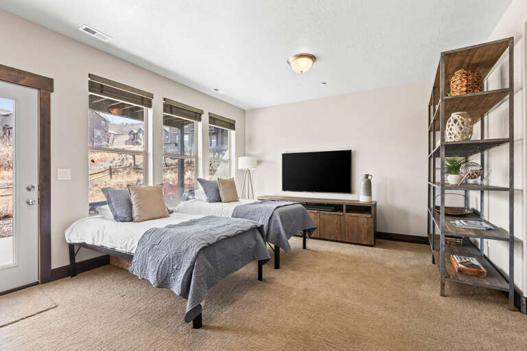Sink into plush twin beds with soft gray linens while enjoying your entertainment center and mountain views through oversized windows.