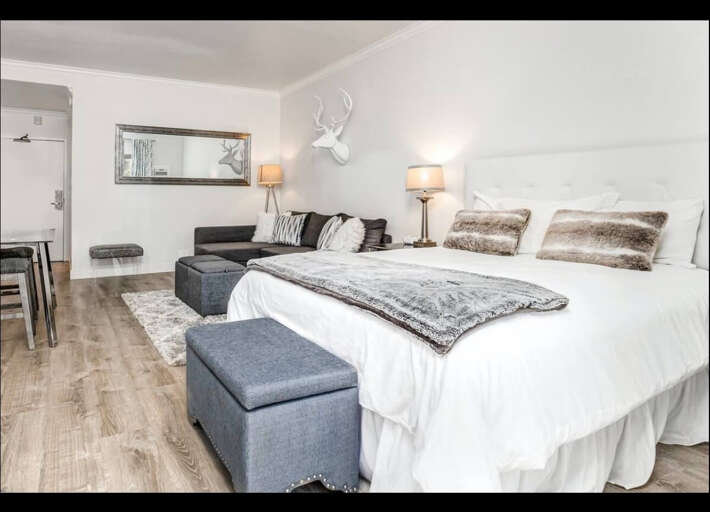 Sink into luxurious comfort in your elegantly appointed suite, where cozy seating and plush bedding create the perfect retreat for relaxation.