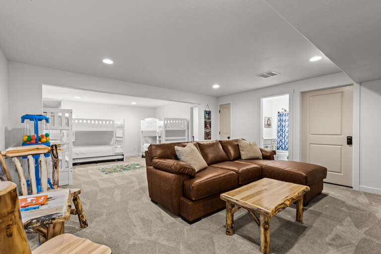 Gather everyone in this spacious lower-level retreat, where kids can claim their favorite bunk while you relax on the plush leather sectional—your family's perfect home base for laughter and downtime.