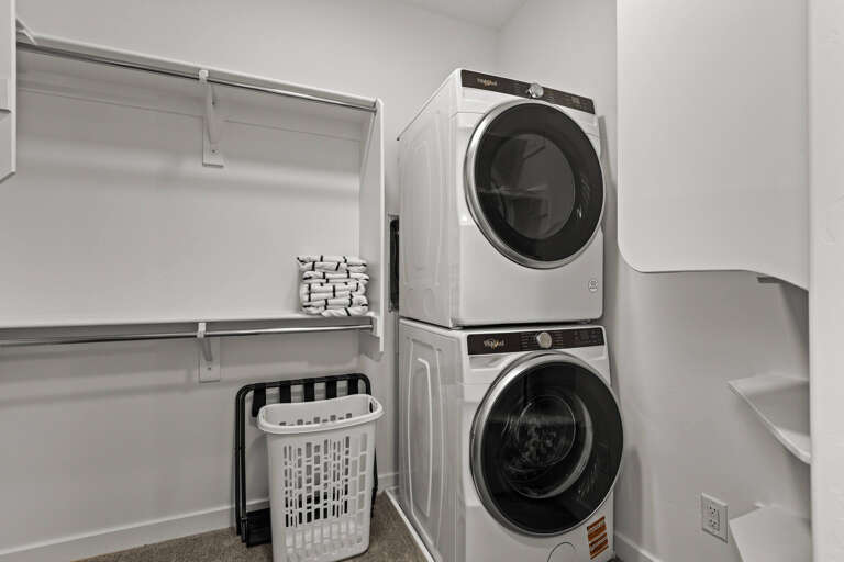 Laundry day made easy with your own in-unit washer and dryer, tucked neatly alongside storage for fresh linens and hanging space.