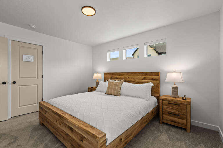 Drift off peacefully in your cozy bedroom, featuring a comfortable bed with crisp linens and warm rustic wood furnishings that create the perfect retreat.