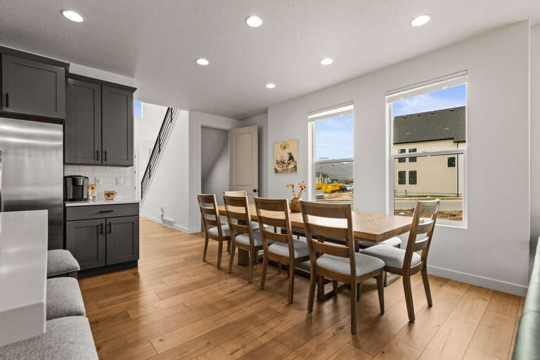 Gather around your spacious dining table for memorable meals, with natural light streaming through large windows and modern kitchen close by.