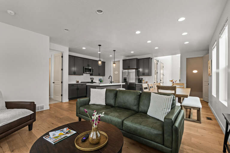Relax in your stylish open-concept space where the emerald leather sofa invites evening conversations while gourmet meals await in your sleek kitchen.