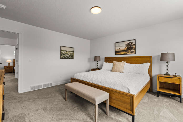Settle into your peaceful bedroom sanctuary with crisp white linens and warm wood accents creating the perfect retreat for restful nights.