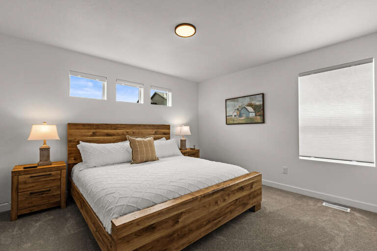 Sink into crisp white linens and rustic wood warmth in your peaceful bedroom retreat with natural light streaming through.
