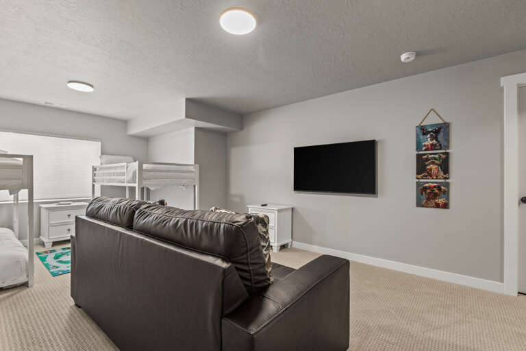 Unwind in your cozy living area with comfortable seating, wall-mounted TV, and bunk beds perfect for family gatherings.