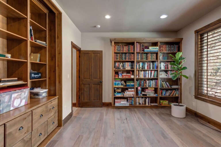 Cozy up in your own private reading nook, where floor-to-ceiling bookshelves and warm wood tones create the perfect retreat for quiet afternoons with a good story.
