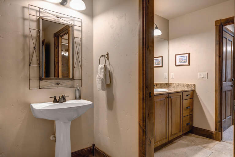 Freshen up in your spacious dual-vanity bathroom, where rustic wood tones meet modern convenience for a restful mountain retreat.