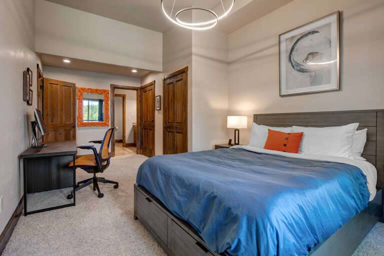 Sink into crisp linens and plush comfort after a day of adventure. Your restful retreat features modern lighting, a cozy workspace, and peaceful mountain views framed by warm wood accents.