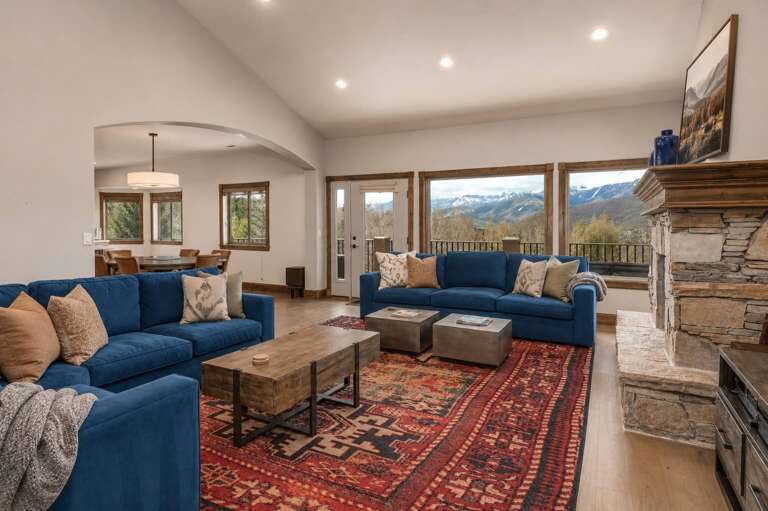 Sink into plush seating and warm yourself by the stone fireplace while taking in sweeping mountain vistas through expansive windowsâyour perfect mountain retreat.