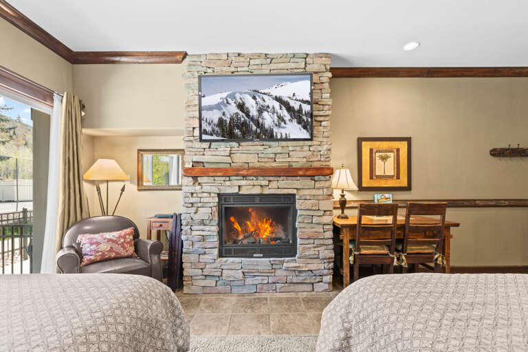 Unwind in your cozy living space with a crackling fireplace and mountain views on the TV, perfect for relaxing aprÃ¨s-ski evenings.