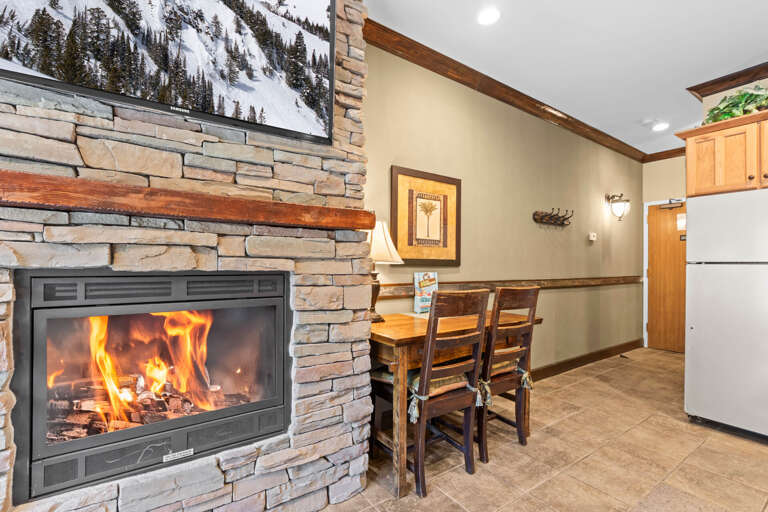 Warm up by the stone fireplace after a day on the slopes, then gather at the dining tableâthis cozy spot blends rustic charm with mountain comfort perfectly.