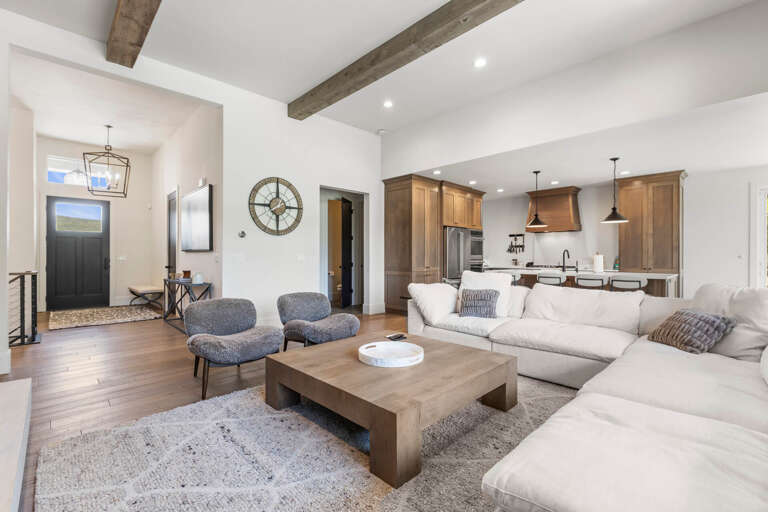 Picture yourself unwinding on the plush sectional, where exposed beams add rustic charm to this light-filled, open-concept living space that flows seamlessly into the gourmet kitchen.