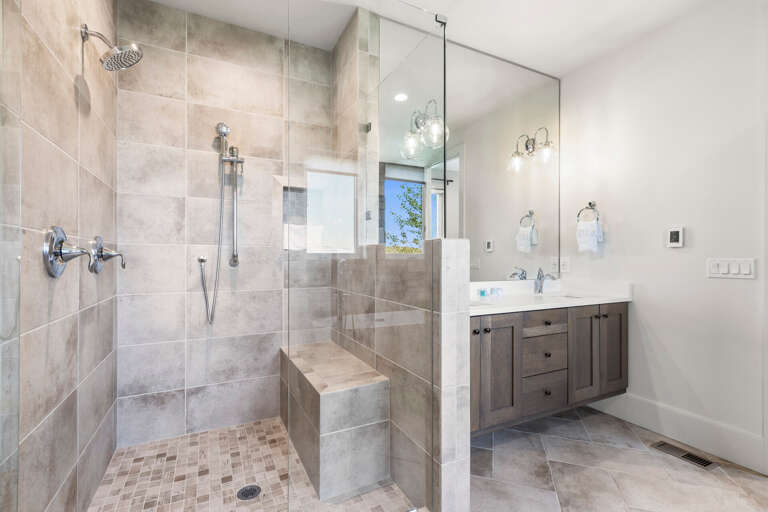 Refresh in your spa-like bathroom with a spacious walk-in shower, dual rainfall showerheads, and built-in bench. Clean lines, elegant fixtures, and natural light create a modern sanctuary for your daily routine.