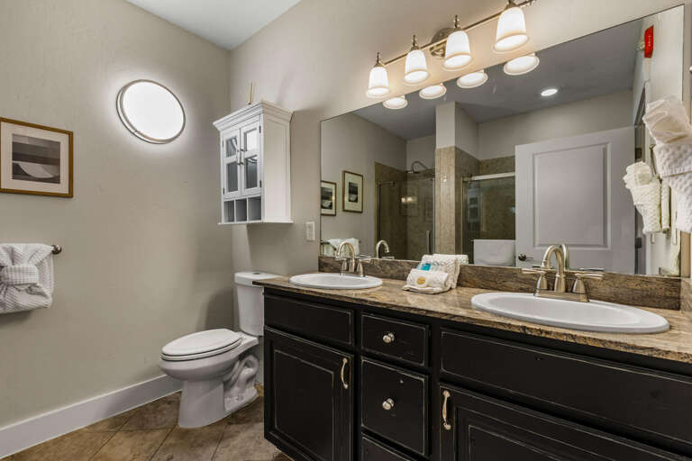 Refresh in your private bathroom featuring dual vanities, elegant granite countertops, modern fixtures, and a walk-in showerâeverything you need for a comfortable stay.