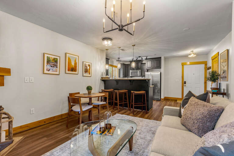 Unwind in your cozy open-concept living space, where warm wood accents and comfortable seating invite you to relax after exploring. The fully-equipped kitchen and dining area make it easy to enjoy meals together.
