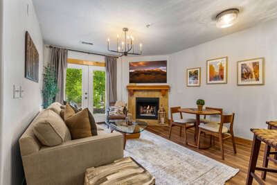 Your warm, sunlit living space invites you to relax by the fireplace or enjoy meals at the cozy dining table while taking in the mountain views above the mantle.