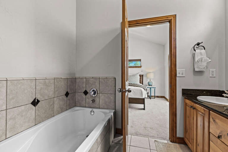 Your private en-suite bathroom features a soaking tub and direct access to a serene bedroom retreatâperfect for unwinding after a day of adventure.