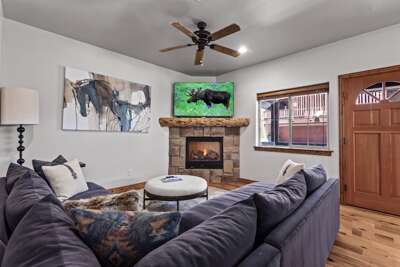 Relax into plush seating by the warmth of your stone fireplace, where rustic charm meets modern comfort in this inviting living space designed just for you.
