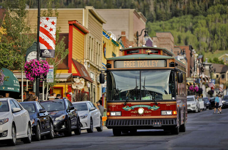 A charming historic mountain town with colorful storefronts, offering easy access to local shops and attractions via the free trolley service visible on the main street.