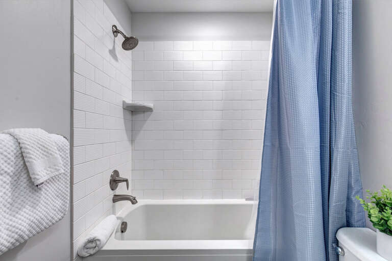 Step into your serene bathroom, where crisp white subway tile and a fresh curtain create a bright, calming space to refresh and unwind.