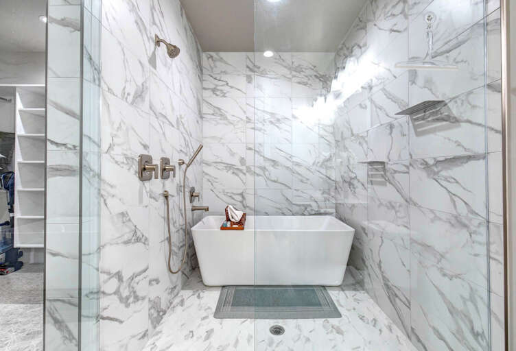 Luxurious marble-wrapped wet room featuring a sleek freestanding tub and modern fixturesâyour private spa retreat awaits.