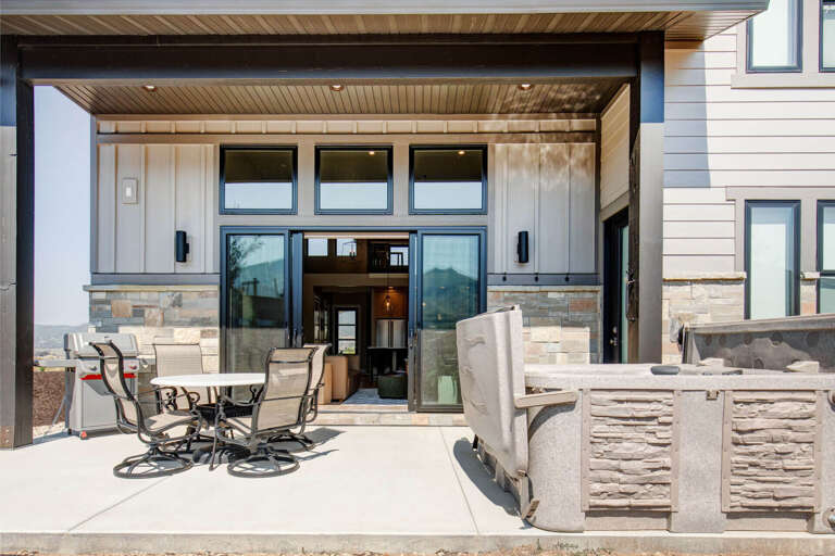 Your private outdoor living area awaits, complete with a covered patio, dining space, and mountain views framing every moment of relaxation.