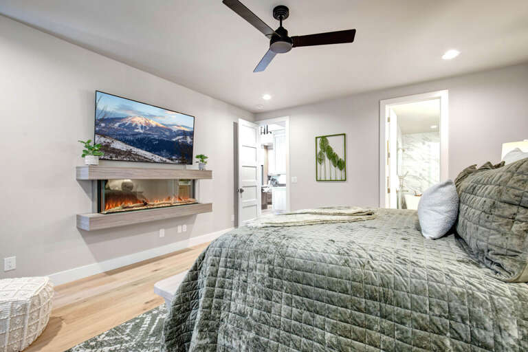 Sink into plush bedding with a cozy fireplace glowing nearby. Your private suite opens to a spa-inspired bath, with soft greenery adding a touch of serenity.