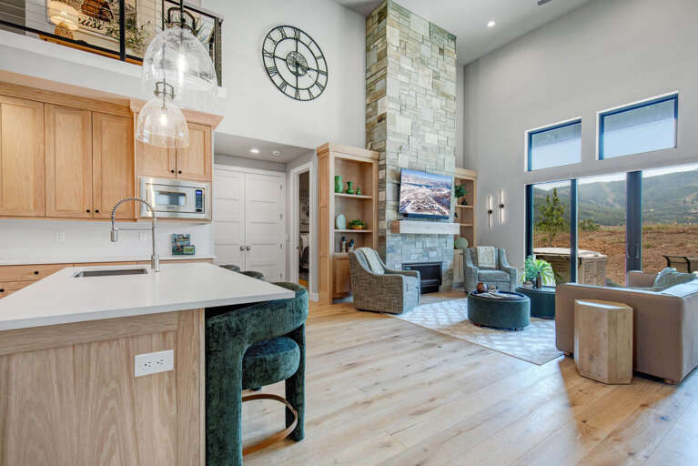 Step into your bright, open-concept retreat where high ceilings and expansive windows frame stunning mountain views. Warm wood tones and modern design create the perfect backdrop for your mountain getaway.
