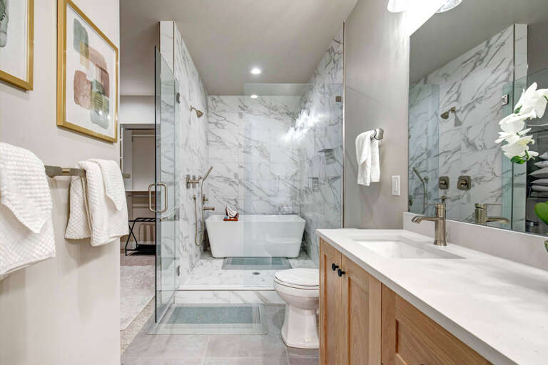 Step into your private spa-like retreat with elegant marble walls, a luxurious soaking tub, and a spacious walk-in shower. Plush towels and fresh orchids await your arrival.