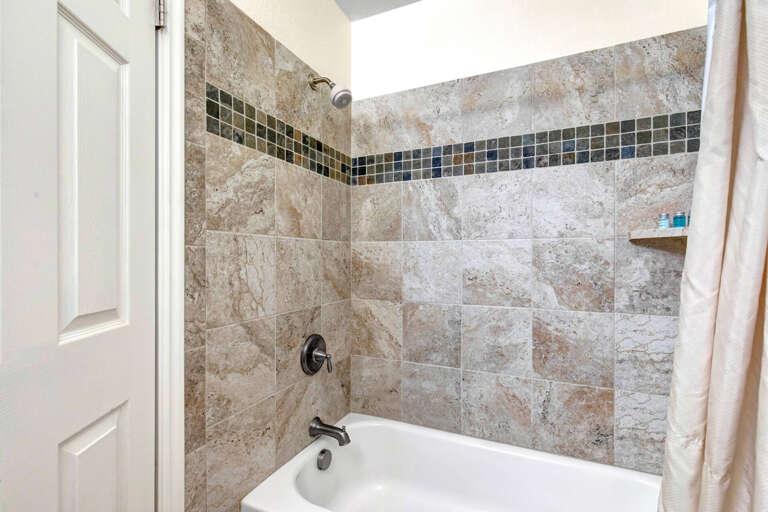 Enjoy your private tub and shower combination with beautiful mosaic tile accents and a skylight overhead for natural light.