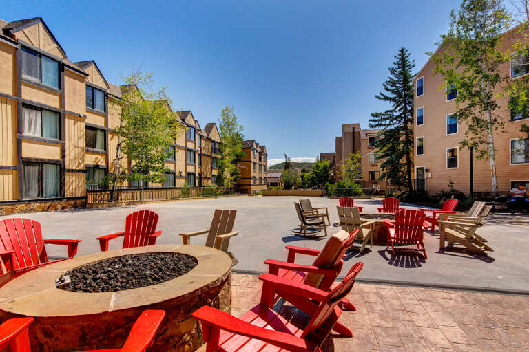 Gather around the fire pit under open skies, sinking into colorful Adirondack chairs while mountain breezes and warm flames create the perfect evening retreat.
