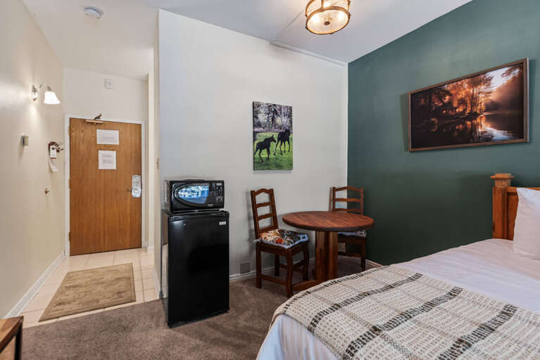 Settle into your cozy retreat featuring a comfortable bed, mini-fridge, microwave, and charming dining nook—everything you need for a relaxing getaway.