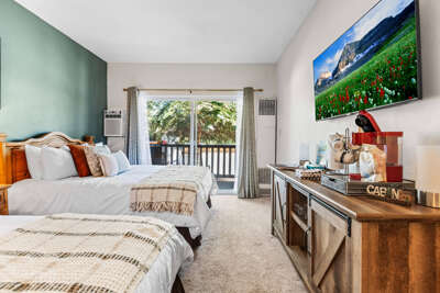 Your cozy bedroom retreat features plush beds with soft linens and opens to a private balcony surrounded by greenery. Enjoy your morning coffee while breathing in the fresh mountain air.