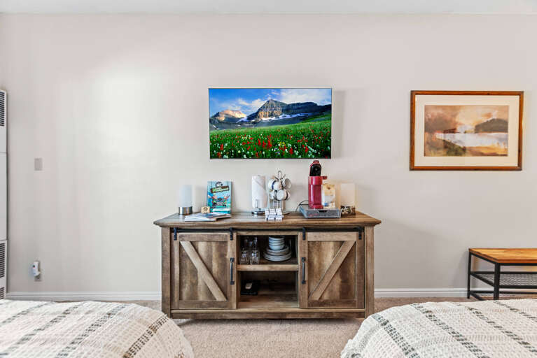Settle into your bright, inviting living area where a rustic credenza doubles as a well-stocked coffee bar—complete with a sleek espresso machine and all the essentials for your morning ritual.